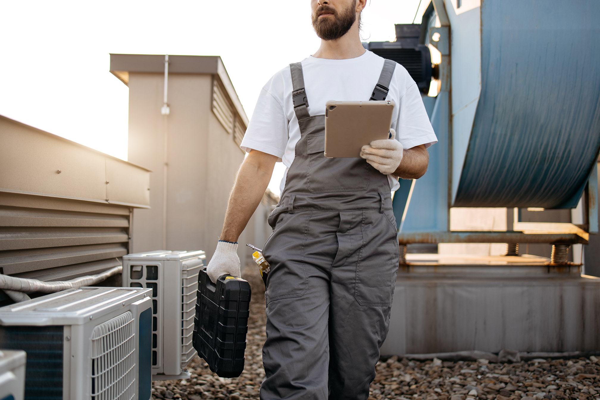 Projects repairman holding tablet and carrying set with tools outside